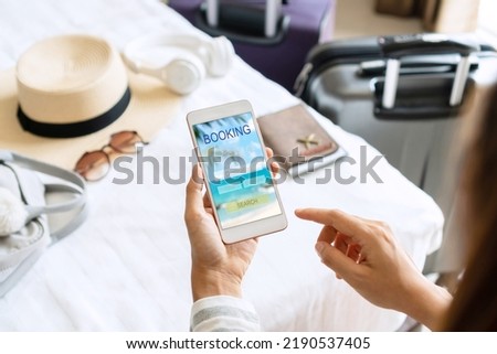 Woman search ticket reservation for holiday. Girl using travel application for flight tickets and hotel room online booking. Online travel agency hotel flight ticket booking, travel planning concept. Royalty-Free Stock Photo #2190537405