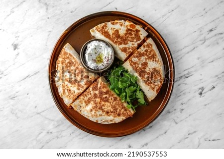 Pita with meat and vegetables in a  plate on a marble background. Restaurant banquet menu.