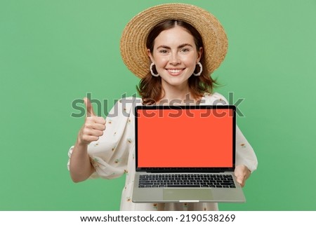 Young fun freelancer fun woman she 20s wears white dress hat hold use work on laptop pc computer with blank screen workspace area show thumb up isolated on plain pastel light green background studio