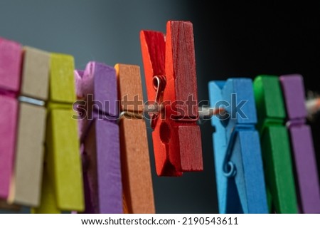 Concept colored wooden clothespins on a ropeclip wooden clothesline colorful. hold
