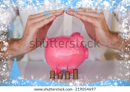 Composite image of casual businessman sheltering piggy bank and coins against snow