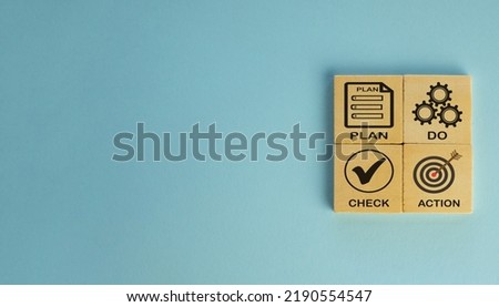 PDCA cycle,PLAN DO CHECK ACTION quality tool for business concept.,PDCA (plan do check action) word and icon on wooden cube with copyspace over blue background.