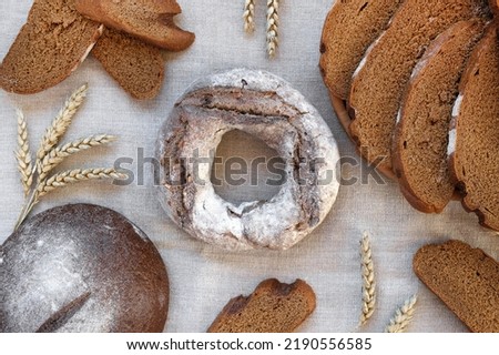 Baked bread. Loaf of Bread. Fresh Bakery Products on Wooden Board. Healthy Food Concept. Top View. Flat lay. Slices of Homemade Sourdough Bread with Flour on Rustic Linen Background. Wheat Spikes.