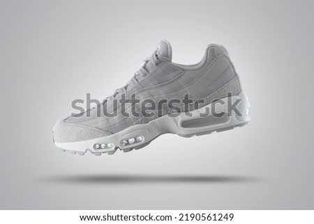 Light Gray sport sneaker, shoe on a gray gradient background, men's fashion, sport shoe,  air, sneakers, lifestyle, concept, product photo,  levitation concept, street wear, trainer