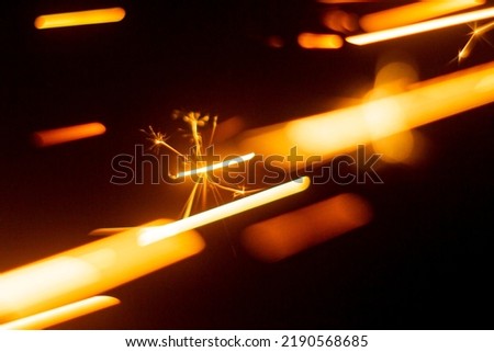 abstract image of sparks from a circular saw, photographed in close-up macro mode. Front and back background blurred with bokeh effect