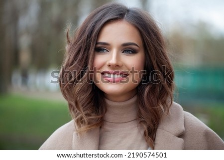 Portrait of happy young brunette woman with wavy brown medium hairstyle, waves with side volume Royalty-Free Stock Photo #2190574501