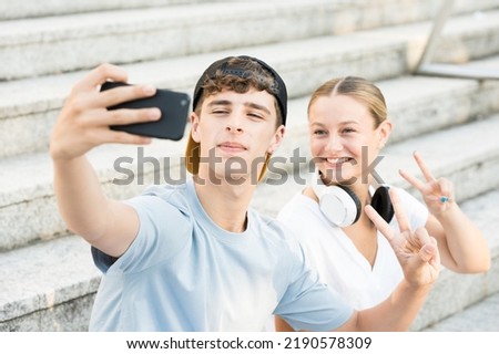 Two friends taking a selfie on stairs.