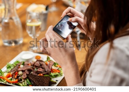 technology and people concept - close up of woman with smartphone photographing food at restaurant