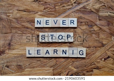 never stop learning text on wooden square, inspiration and motivation quotes