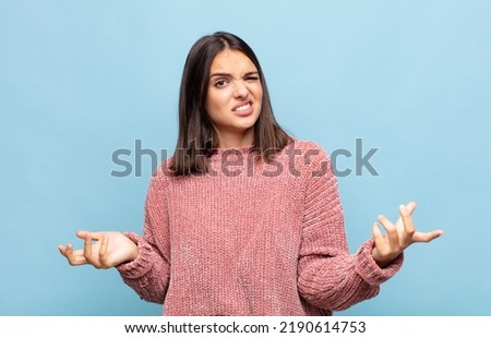 young pretty woman shrugging with a dumb, crazy, confused, puzzled expression, feeling annoyed and clueless Royalty-Free Stock Photo #2190614753