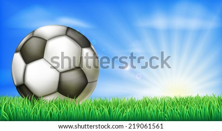 A soccer football in a green grass field pitch with sun rise.