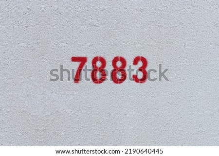Red Number 7883 on the white wall. Spray paint.

