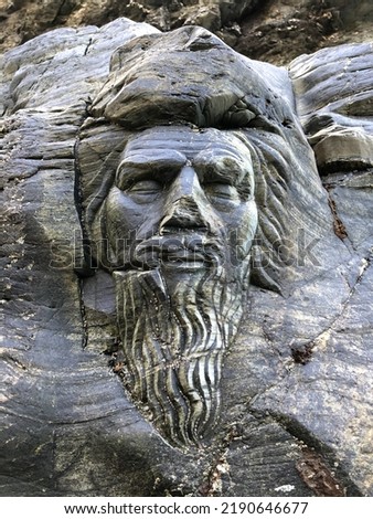 Merlin’s face carved into the rocks on the beach at Tintagel, Cornwall Royalty-Free Stock Photo #2190646677