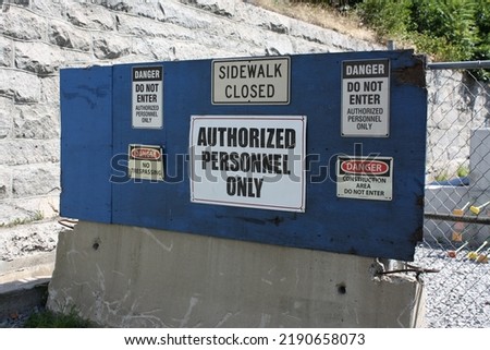 Multiple warning signs: authorized personnel only, do not enter, sidewalk closed, danger, no trespassing.