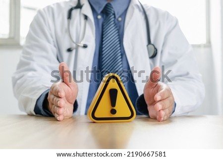 Warning symbol in hand of doctor. Doctor's warning, Precautions for epidemic diseases, Concept of caution.