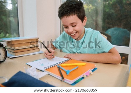 Handsome successful kid, smart elementary school student, school boy doing math and geometry homework. Homeschooling. Opening a new subject in the new semester of the academic year. Back to school