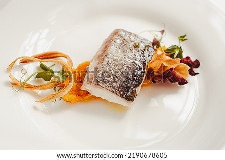 The Sea Bass (branzino) is a typical main course on the italian tables. Here's a gourmet plating. Royalty-Free Stock Photo #2190678605