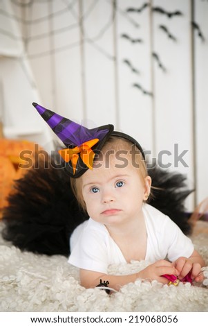 beautiful little girl with Down syndrome in a suit a little witch