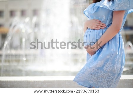 Pregnant girl in a dress in nature on a walk
