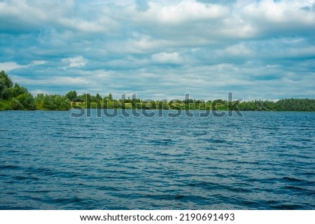 River bay, forest on the shore. A beautiful bay overgrown along the shore with a green forest under a deep blue sky