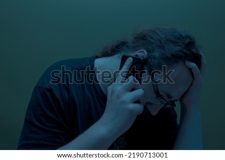 Desperate worried man talking on the phone in the dark. Blackout concept. Selective focus. power outage Royalty-Free Stock Photo #2190713001