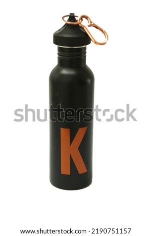 close up of a black steel thermos drinking water bottle that can be reused over and over again. Eco-friendly thermos with K text. isolated on white with copy space.