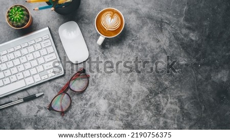Top view, Dark Office desk with keyboard computer, cup of coffee, mouse, eyeglass and pen, copy space, Mock up...	

