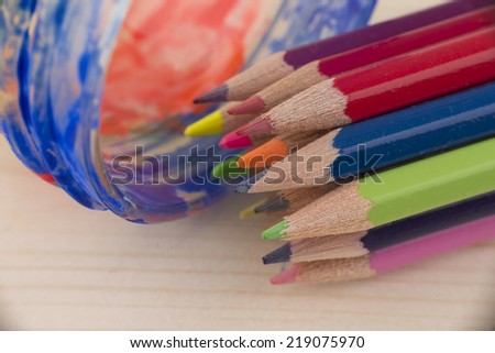   Assortment of colored pencils on the wooden table,on the painted paper
