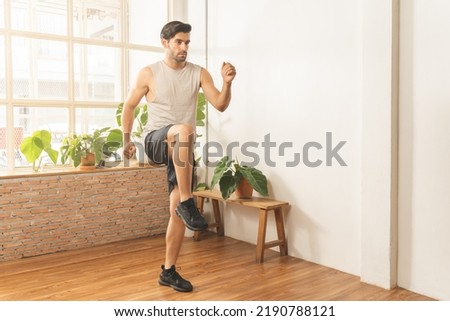 Handsome fitness caucasian young man, guy wearing sportswear training strength muscles workout, cardio exercise training in living room at home for healthy body strong athletic, fit active lifestyle Royalty-Free Stock Photo #2190788121