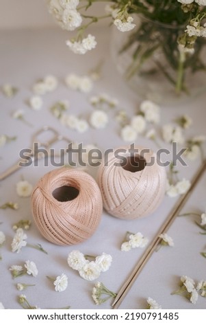 Cotton, flowers, needles, scissors, yarn, on a rustic background