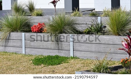 Concrete sleeper retaining wall designed to look like wood Royalty-Free Stock Photo #2190794597