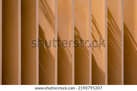 Sunlight and shadow on surface of vertical Wooden Shading Fins outside of Vintage House Royalty-Free Stock Photo #2190795207
