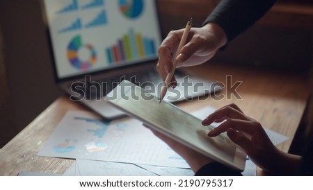 Businessman discussing and summarizing company profit with successful performance graph. A colleague examines the results of the quarterly report using a laptop and notebook graphing business idea. Royalty-Free Stock Photo #2190795317