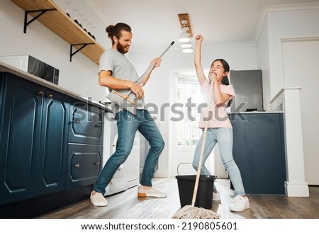 Having fun doing chores, dancing and singing father and daughter cleaning the living room together at home. Carefree, happy and cheerful parent bonding, doing housework and playing with little girl Royalty-Free Stock Photo #2190805601