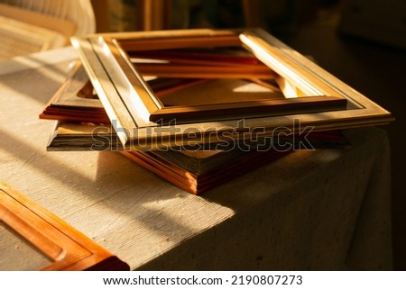 Backlit picture frames, with shadows cast from a window in the late afternoon sun.