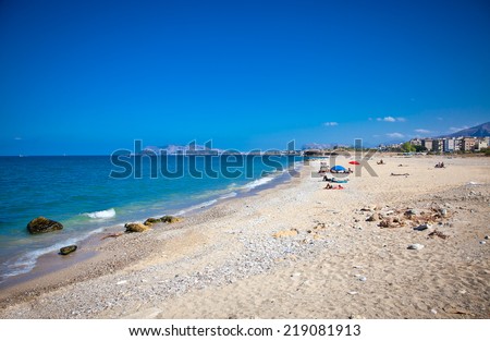 People enjoying sunny day on the pablic beach of Palermo. Sicily.