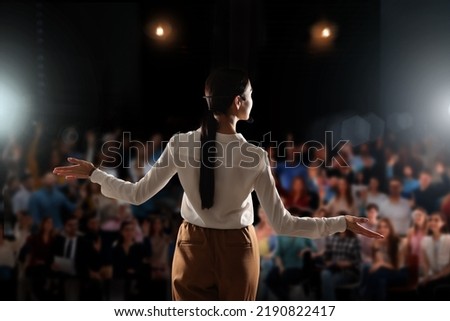 Motivational speaker with headset performing on stage, back view Royalty-Free Stock Photo #2190822417