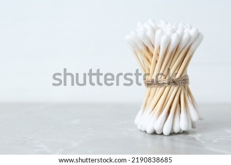 Many cotton buds on light grey marble table, space for text