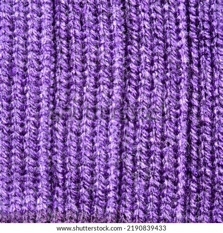 Pattern fabric made of wool. Handmade knitted fabric purple wool background texture