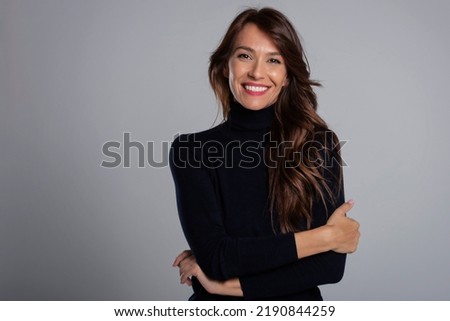 Portrait of beautiful middle aged woman with brunette hair. Confident female wearing black turtleneck sweater while posing at dark background. Copy space.  Royalty-Free Stock Photo #2190844259