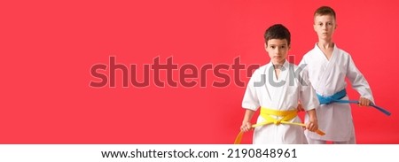 Little boys in karategi on red background with space for text Royalty-Free Stock Photo #2190848961