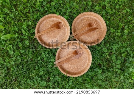 Group of dry biodegradable empty new bran plates and edible fork, knife and wheat bran. Perfect zero waste tableware for garden party. Flat lay view. Royalty-Free Stock Photo #2190853697