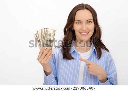 brunette caucasian woman in blue shirt with dollars in hands on white background