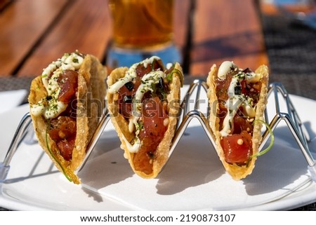 Mexican tacos with beef, tomatoes, chilli and onions in restaurant.