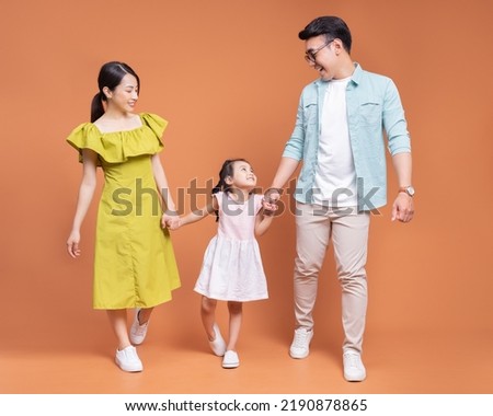Young Asian family posing on background