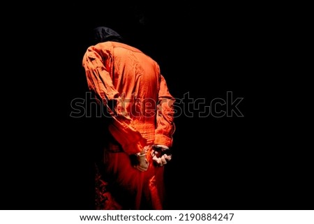 Handcuffs on Accused Criminal in Orange Jail Jumpsuit. Law Offender Sentenced to Serve Jail Time, in black background
 Royalty-Free Stock Photo #2190884247