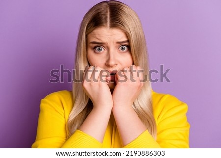 Photo of young lady bite fingers teeth worried scared nervous fear isolated over violet color background.