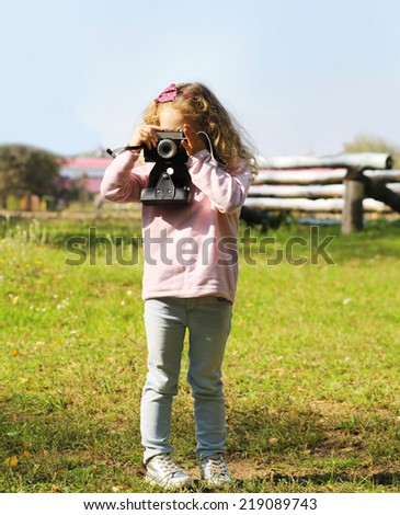 Little child with old retro vintage camera autumn outdoors
