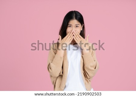 Shocked young asian woman wearing casual standing covering mouth with hands looking camera isolated on pastel pink colour background studio portrait. Royalty-Free Stock Photo #2190902503