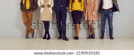 People in smart casual clothes by office wall. Row of company employees in pants, skirts, jackets and jumpers of brown, yellow, dark blue, beige color. Low section legs. Work dress code concept Royalty-Free Stock Photo #2190910185